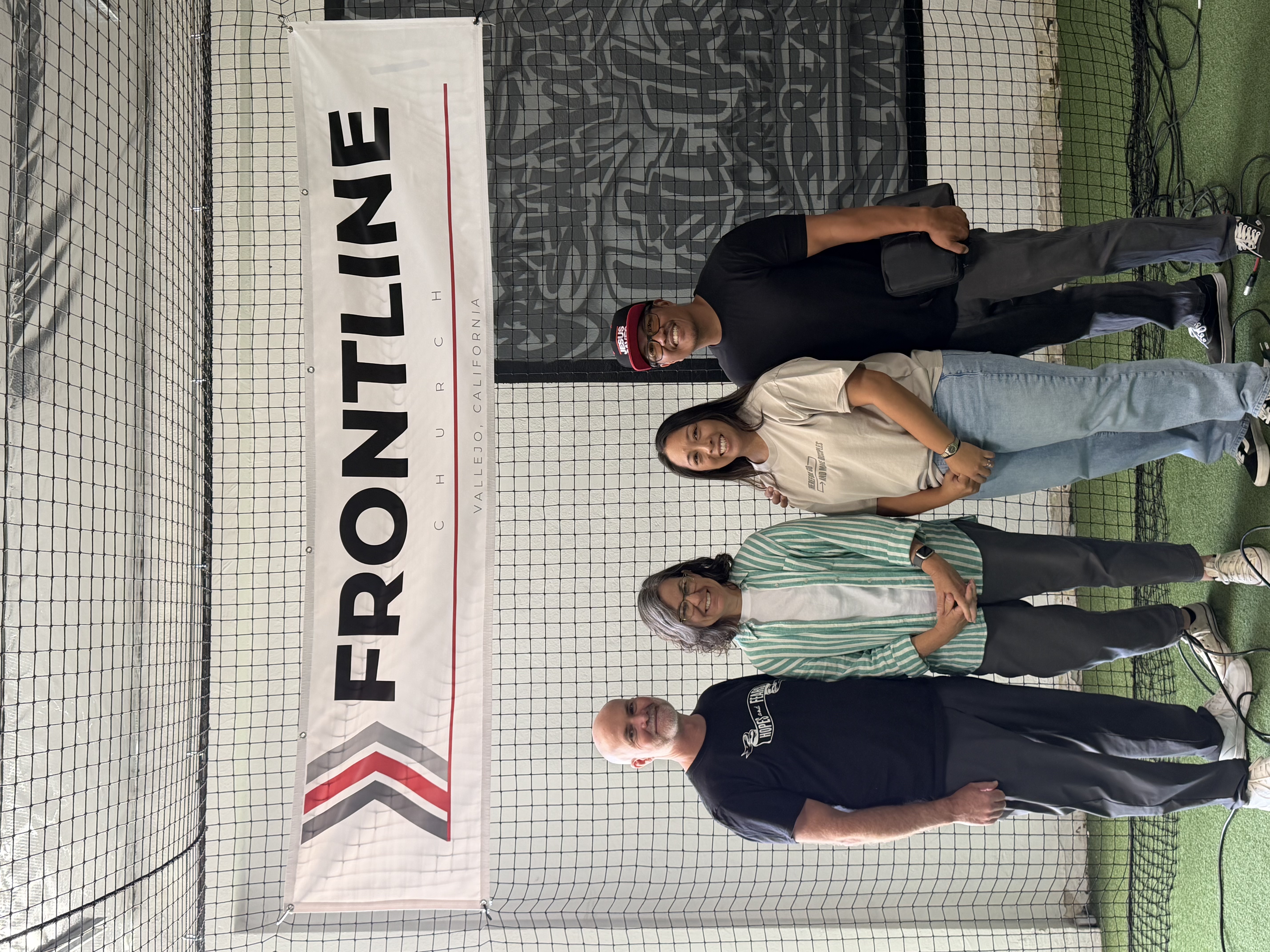Four people standing beneath the Frontline Church banner in Vallejo