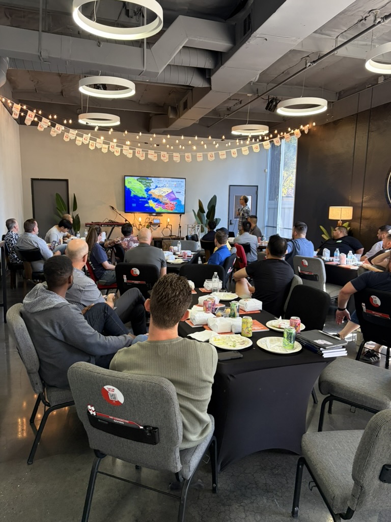 People seated around tables during a Bay Area network meeting