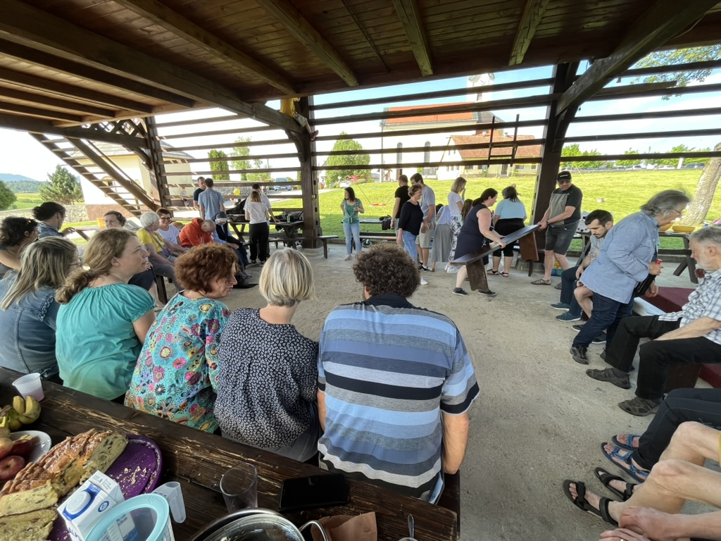 A church community gathered under an outdoor shelter